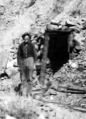 Jim Wheelock standing by tunnel at his Connor Creek mine in 1930's